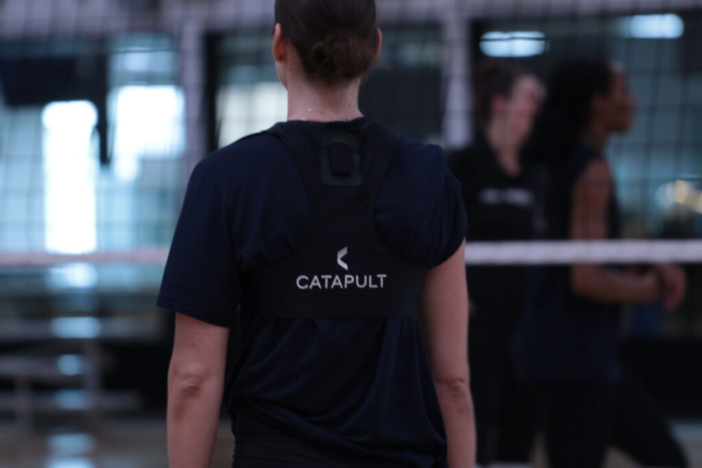 モニタリングベストの Catapult のロゴが見える、女子バレーボール選手の後ろ姿のクローズアップ。