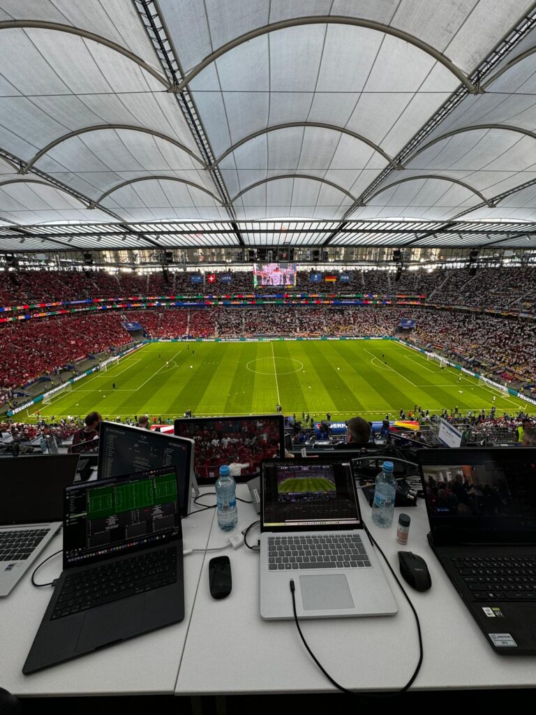 Multiple laptops at a stadium showing live match analysis using the Catapult Pro Video platform.